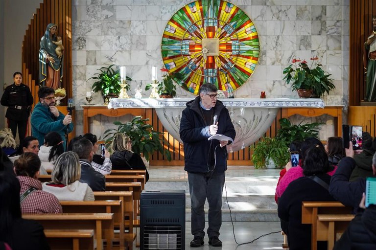Alcuni residenti del Parco Verde, con l'alloggio sequestrato per occupazione abusiva, riuniti in chiesa per ascoltare, letta da don Maurizio Patriciello, la nota della procura che allontana il rischio di sgombero - Ansa