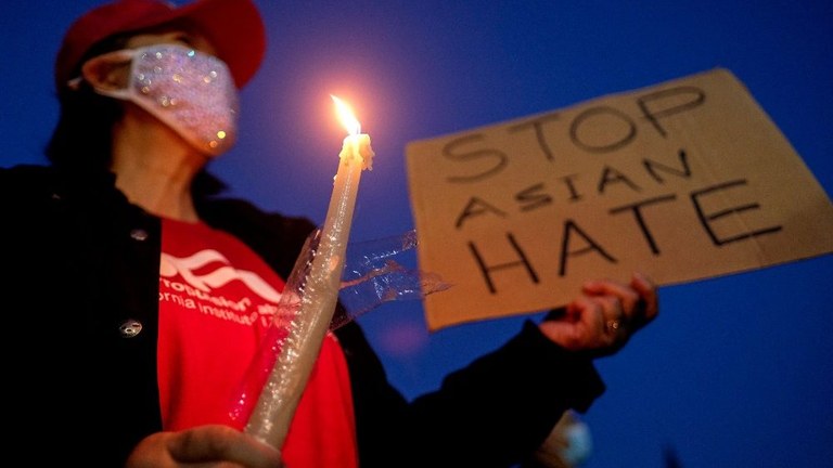 Stati Uniti: Una donna con una candela e un cartello contro la discriminazione razziale