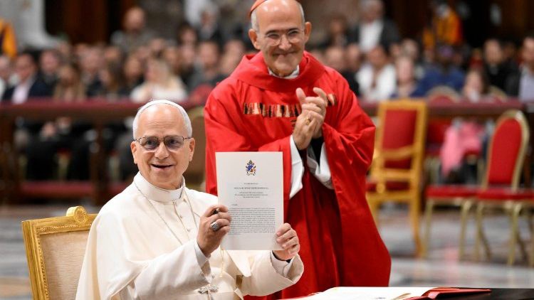 Papa Leone XIV mostra la Lettera apostolica "Disegnare nuove mappe di speranza" dopo la firma nella Basilica Vaticana. Accanto, il cardinale José Tolentino de Mendonça, prefetto del Dicastero per la cultura e l’educazione
